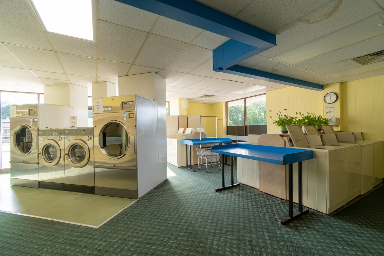 Wide view of folding tables and front-loading washers inside Rockford Washer